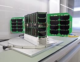 Der Würzburger Satellit SONATE-2 ist in etwa so groß wie ein Schuhkarton. Seine Solarpaneele sind hier ausgeklappt. (Bild: Robert Emmerich / Universität Würzburg)