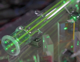 Jodmoleküle in einer Dampfzelle geben den Takt der laseroptischen Uhr an. Mit Hilfe eines Lasers wird die optische Uhr auf eine quantenphysikalisch gegebene Schwingung von Jodmolekülen abgestimmt. Wenn das Laserlicht und eine ausgesuchte Schwingung der Jodmoleküle in Resonanz sind, leuchten diese grün. (Bild: DLR (CC BY-NC-ND 3.0))