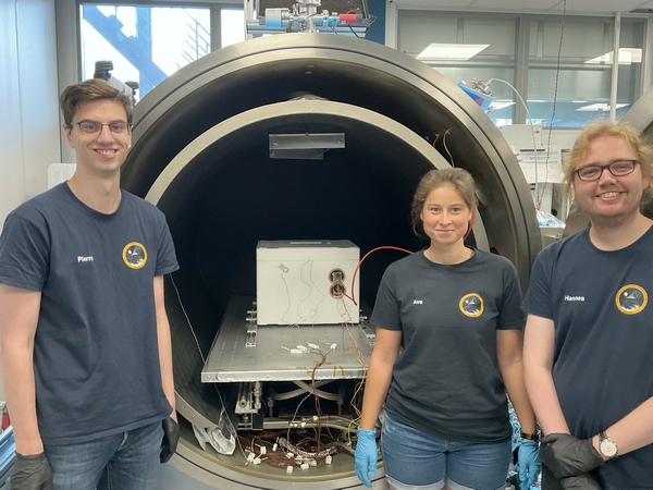 Die Teammitglieder Pierre, Ava und Hannes (v.l.) prüfen bei einem Vakuumkammer-Test, ob die Messungen mit CHAOS auch bei Druck- und Temperaturveränderungen funktionieren. (Bild: Hannes Ebeling, Uni Kiel)