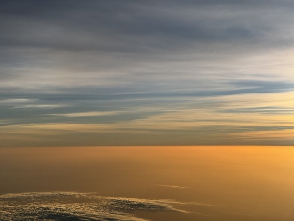 Einfluss von Sahara-Staub Über Cabo Verde zeigen sich häufig starke Einflüsse von Sahara-Staub. In der oberen Bildhälfte zeigt sich das Licht der untergehenden Sonne, die rötliche Färbung der Luftschicht darunter stammt jedoch von Sahara-Staub. Die Staubschicht ist so trübe und weitläufig, dass sie den Horizont vollständig bedeckt wie der Blick aus HALO hier zeigt. (Bild: B. Stevens)